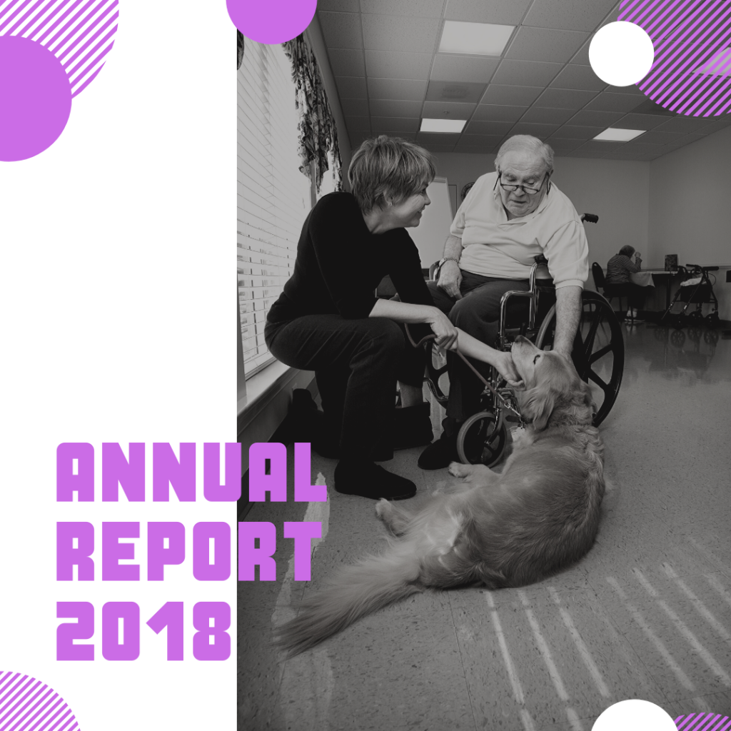 Annual Report 2018 - An older, balding man in a wheelchair and a middle-aged, short-haired woman patting a golden retriever assistance dog.